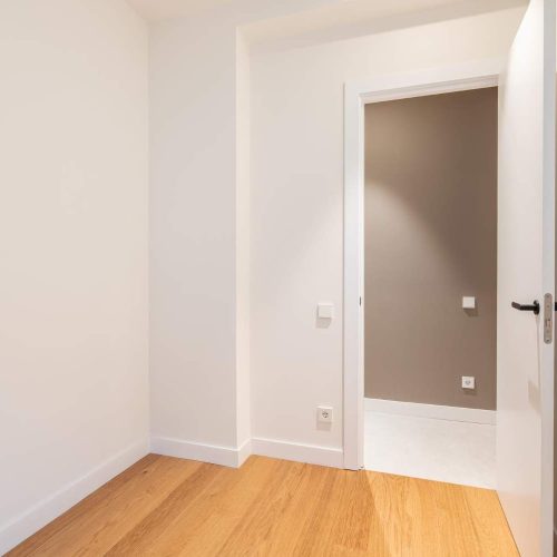 empty-room-with-laminate-flooring-and-newly-painted-white-walls-repair-and-construction-concept (1)